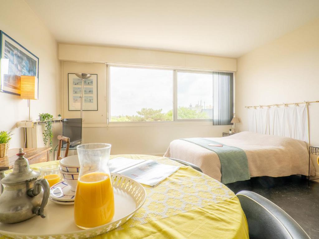比亚里茨Apartment Château d'Arcadie-1 by Interhome的配有床和桌子的房间,提供橙汁