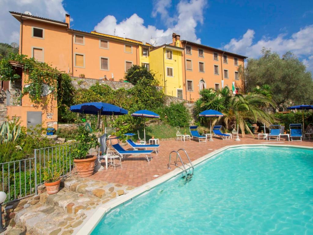 马萨罗萨Apartment Alice by Interhome的酒店设有带椅子和遮阳伞的游泳池
