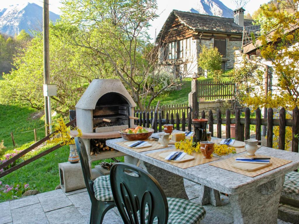 Aquila玛丽安拉奎拉度假屋的院子里的桌子和椅子,带比萨饼烤箱