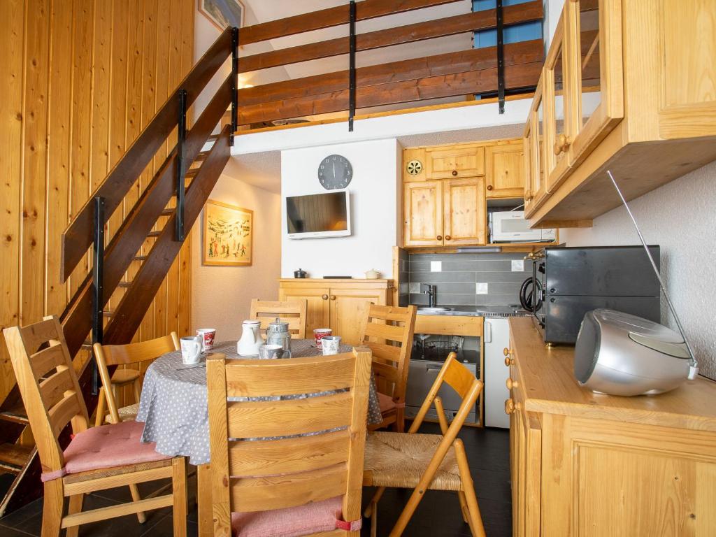 里蒙纽耶Apartment Les Asters-1 by Interhome的一间带桌椅和楼梯的厨房
