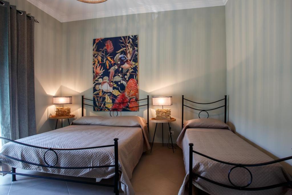 安齐奥Alloggi Villa Sarsina的墙上画画的房间里设有两张床