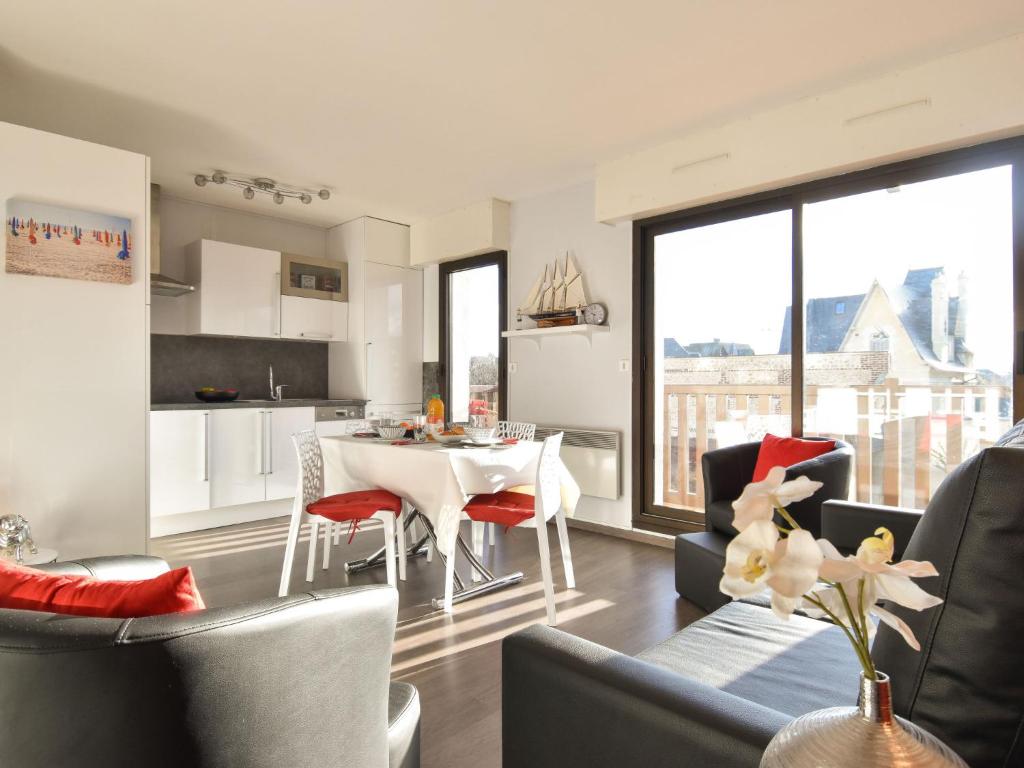 多维尔Apartment Baccara by Interhome的厨房以及带桌椅的起居室。