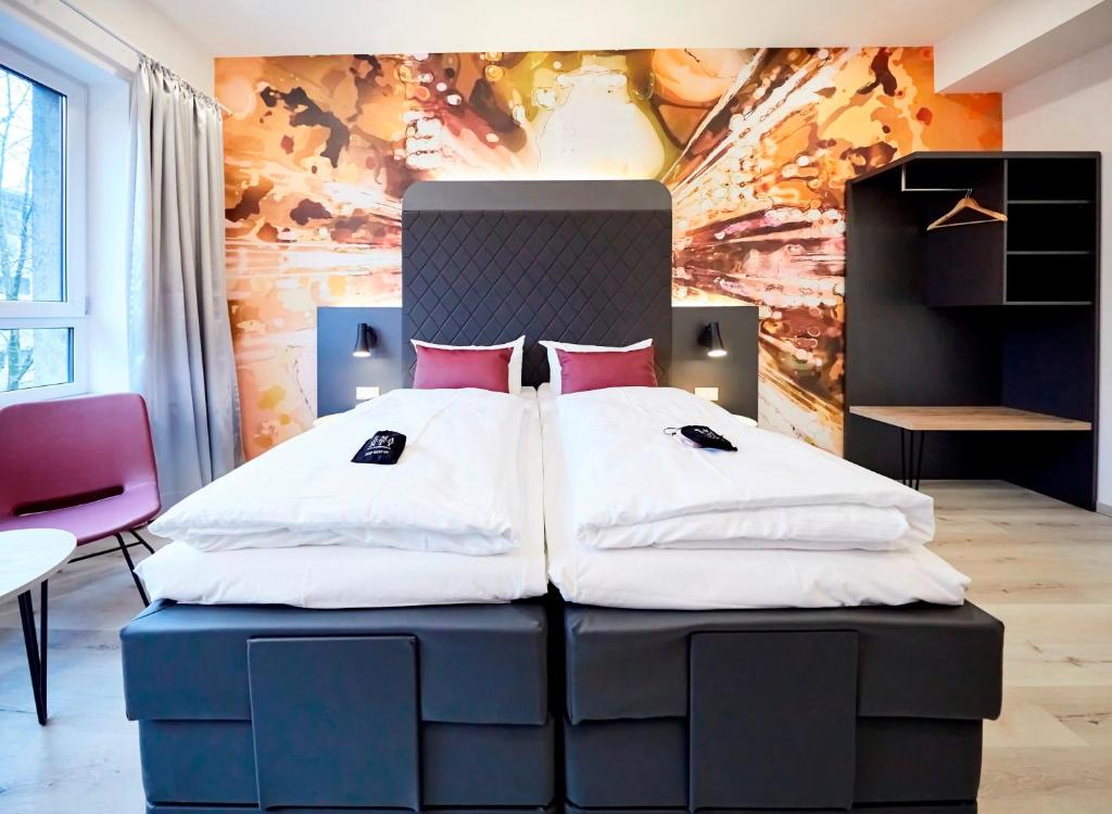 科隆SMARTY Cologne Dom Hotel - Boardinghouse - KONTAKTLOSER SELF CHECK-IN的一间卧室配有一张带红色枕头的大床