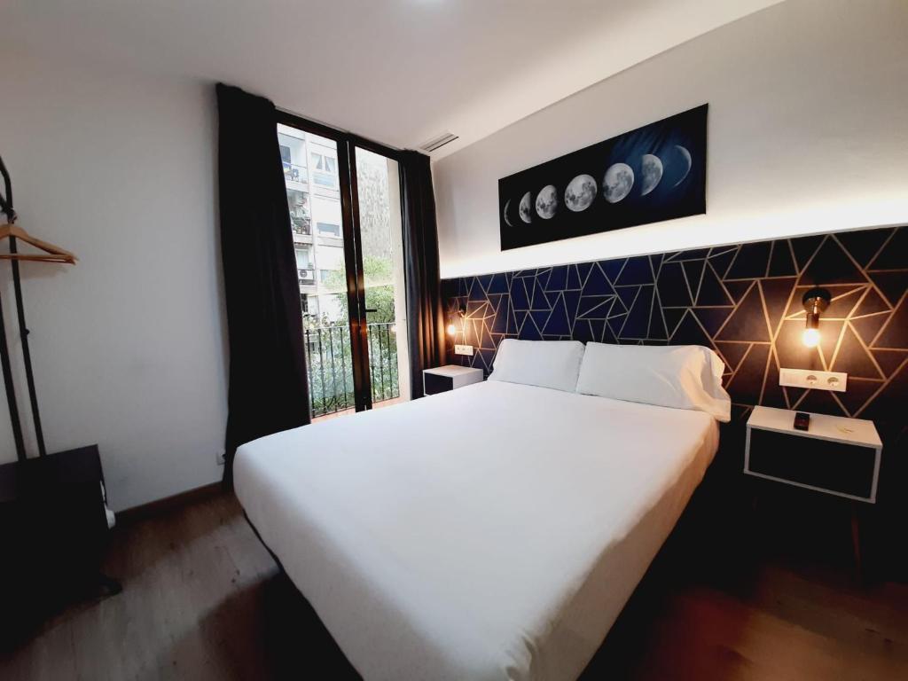 巴塞罗那Hostal Laia by gaiarooms的卧室设有一张白色大床和一扇窗户。