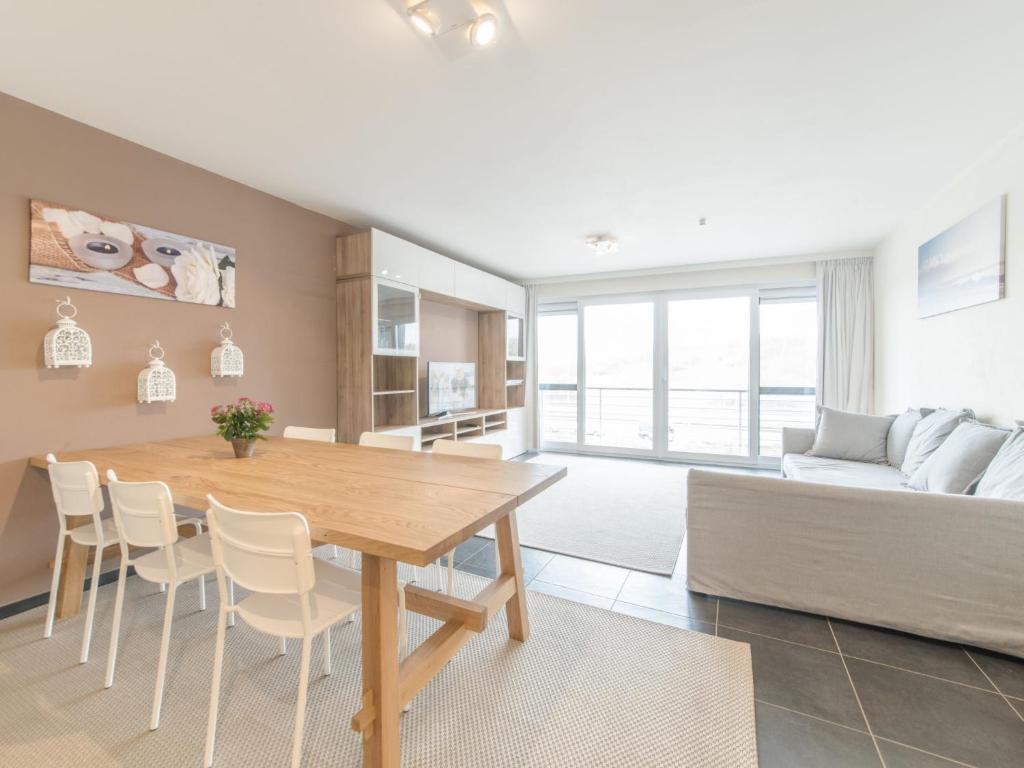 布列登Apartment Residentie Albatros by Interhome的厨房以及带木桌和椅子的客厅。