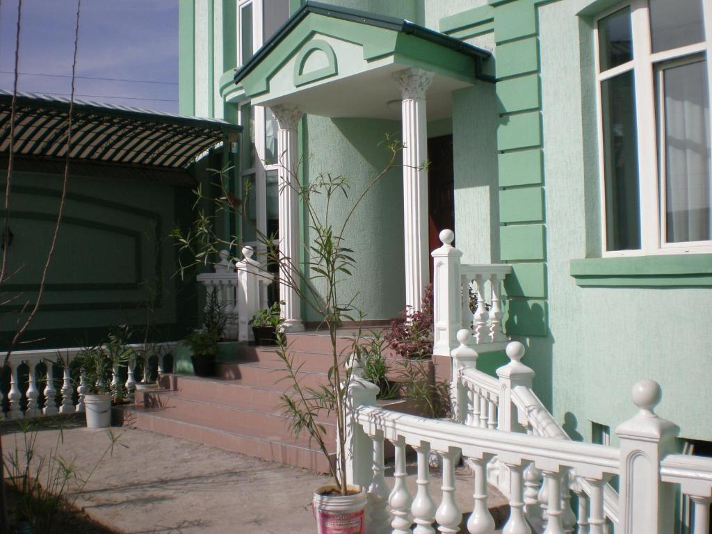 塔什干塔什干加翁吉尔住宿加早餐旅馆的白色围栏和盆栽门廊的房子