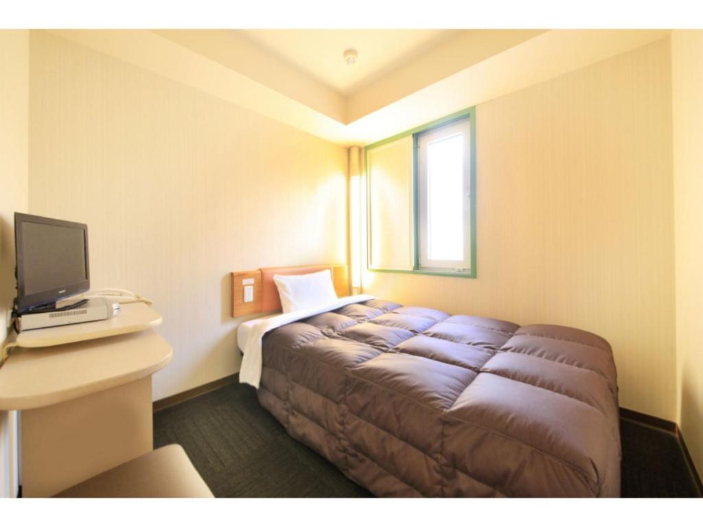 仙台R&B Hotel Sendai Hirosedori Ekimae - Vacation STAY 39659v的一间带床的卧室,位于带窗户的房间内
