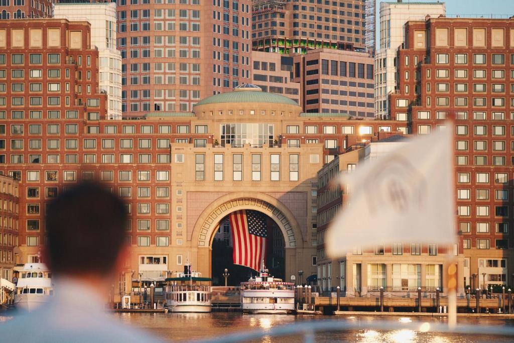 波士顿波士顿海港酒店的一座在城市前悬挂美国国旗的建筑
