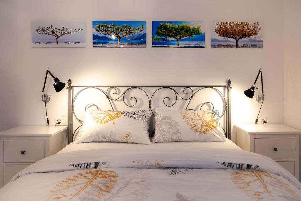 阿斯科纳Casa Alice Ascona, appartamento di vacanza.的卧室配有一张墙上三幅照片的床