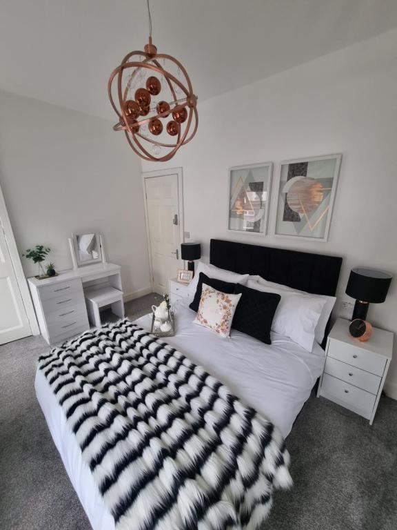 Mountain AshBronallt luxury的一间卧室配有一张大床,提供黑白毯子