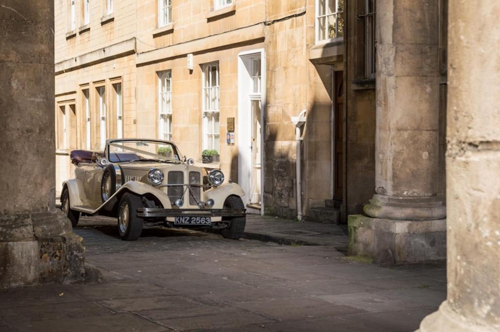 巴斯Abbey Mews in the heart of Bath的一条在小巷里街道上停放的老车