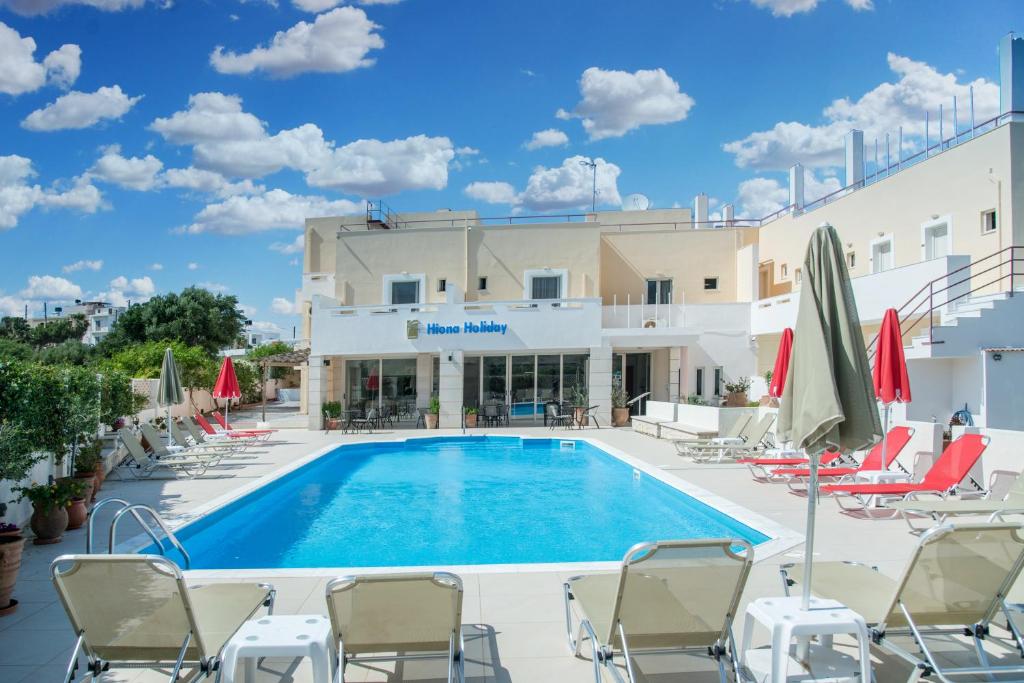 古卡斯特隆Hiona Holiday Hotel的游泳池,带椅子和遮阳伞