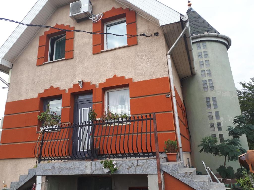DiósdSárkány Lak的一座拥有橙色装饰的建筑和一个阳台