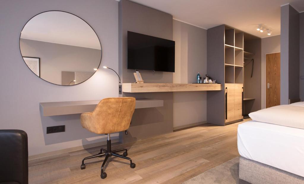 巴特本特海姆Am Berghang的一间卧室配有书桌、镜子和椅子