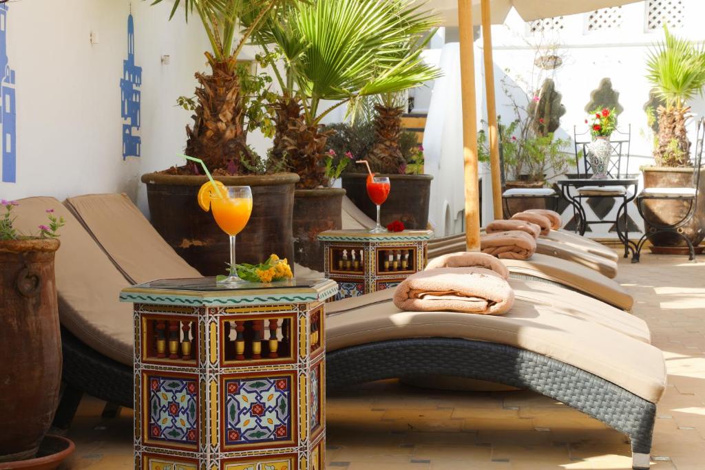 马拉喀什Riad Palais Des Princesses & Spa的一间设有床和两张桌子的房间,以及植物