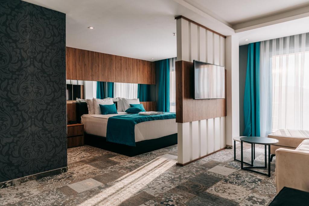 米特罗维察Palace Hotel & SPA的酒店客房,配有床和沙发