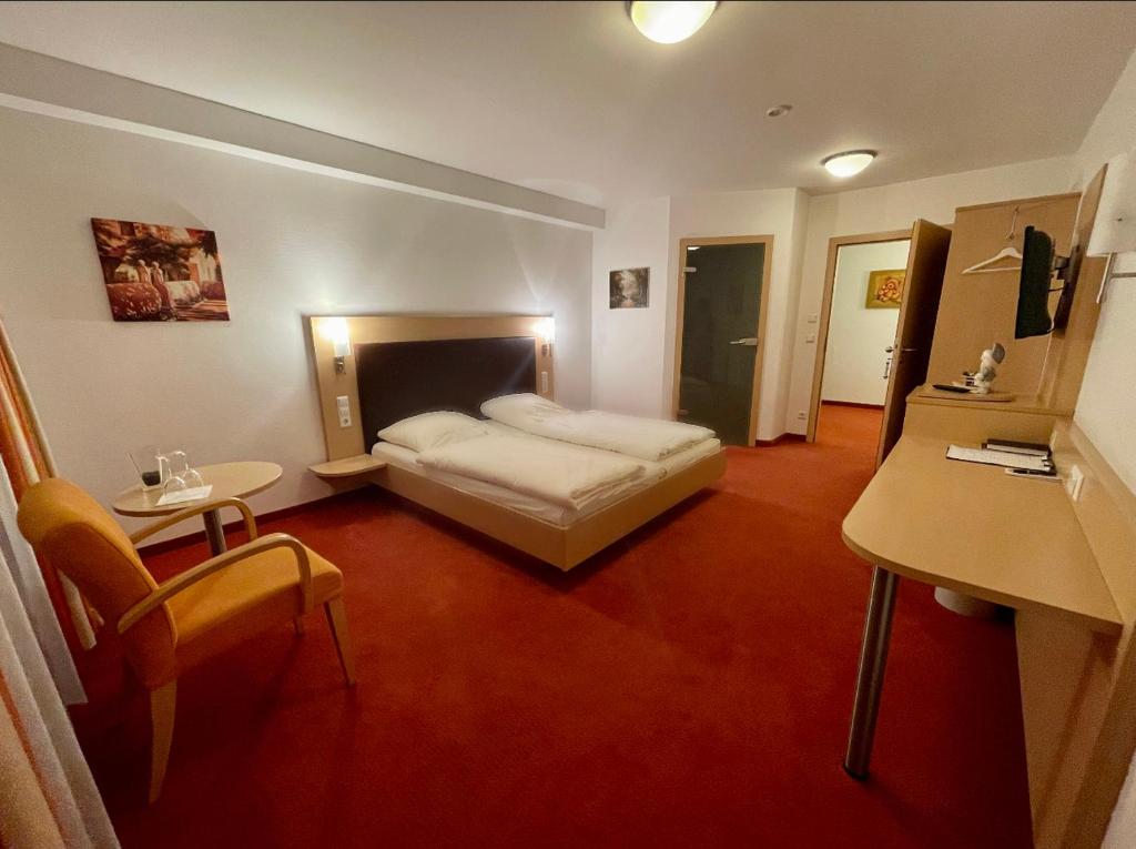 斯图加特LILTON Hotel Stuttgart-Zuffenhausen的一间卧室配有一张床、一张桌子和一张书桌