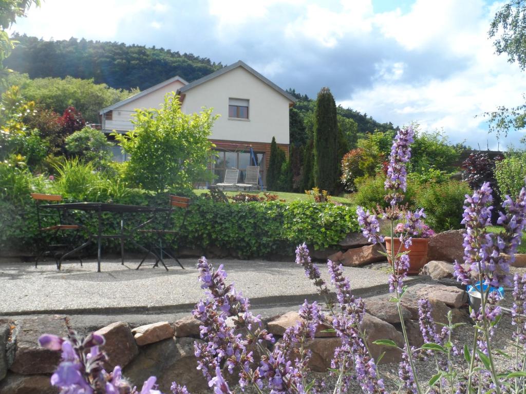 于瑟朗莱城堡雷切尔施耐德住宿加早餐旅馆的一座花园,在房子前面种有紫色的花朵