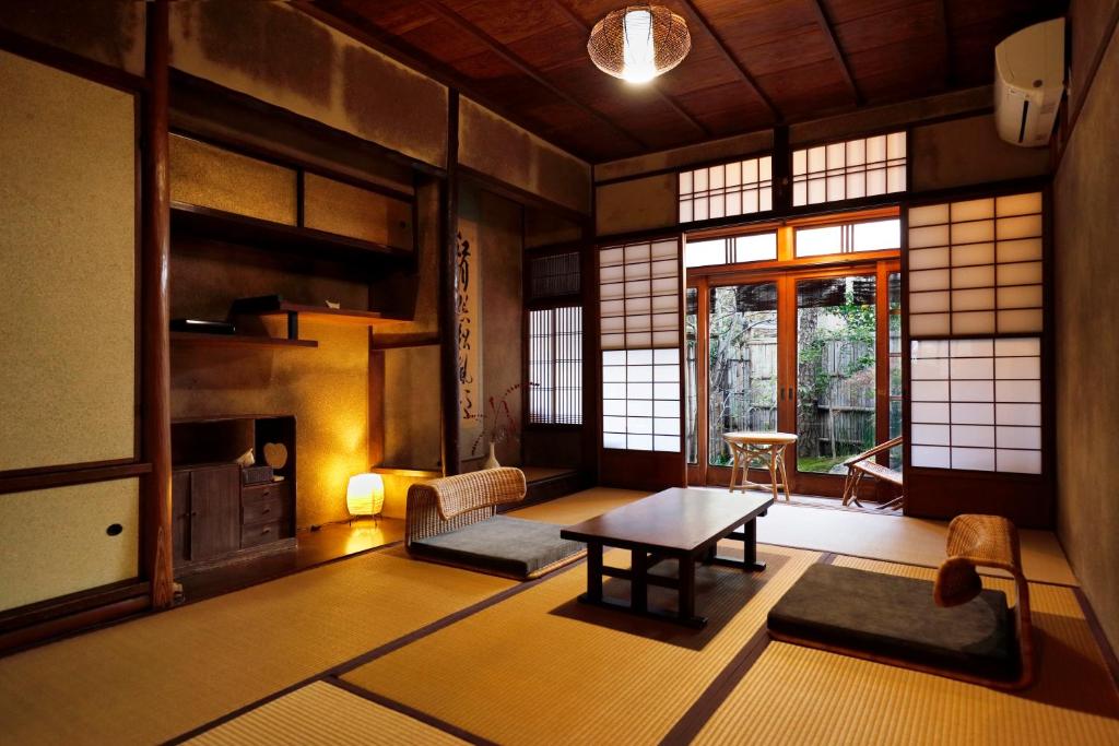 京都Azukiya的带窗户的客房内设有带桌子的客厅