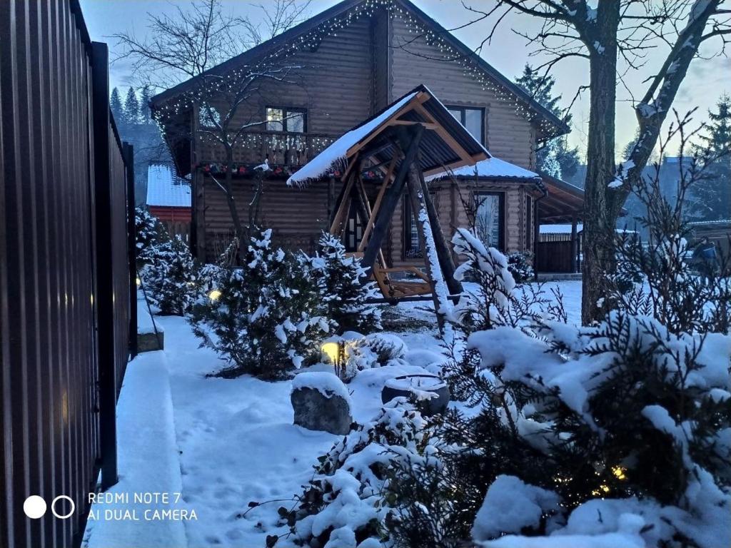 米库利钦Берлога 2的雪中小木屋,配有圣诞灯