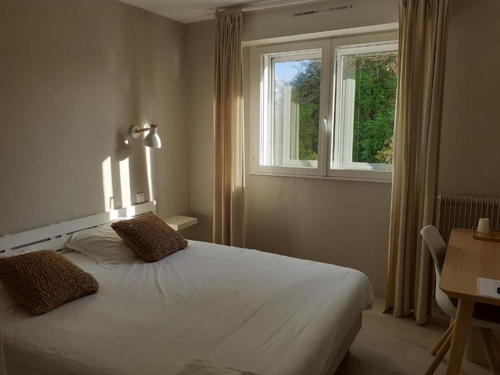 拉内斯泰尔Fuzei Hôtel Lorient-Lanester的卧室配有白色的床和窗户。