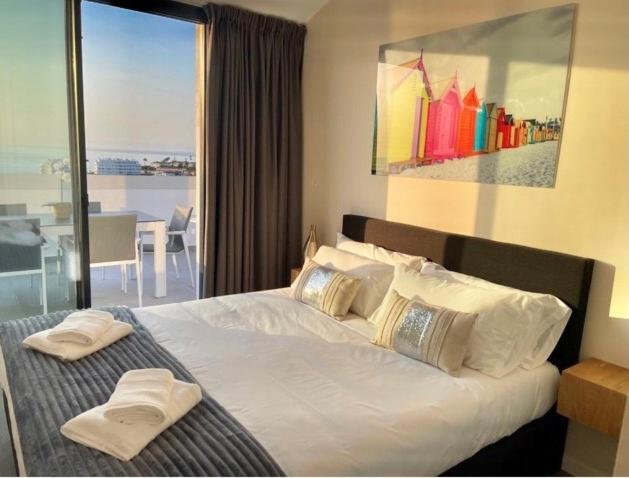 福恩吉罗拉Luxury Penthouse Pedro - The View Fuengirola的一间卧室设有一张大床和大窗户