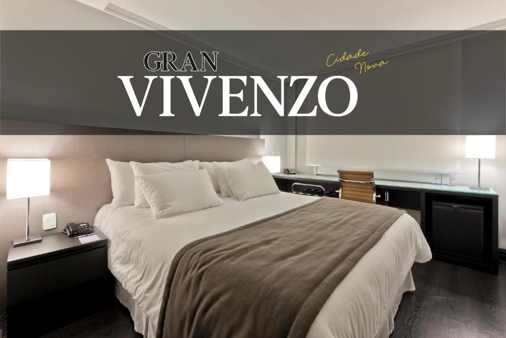 贝洛奥里藏特Hotel Gran Vivenzo Belo Horizonte的卧室配有一张大床,墙上有标志