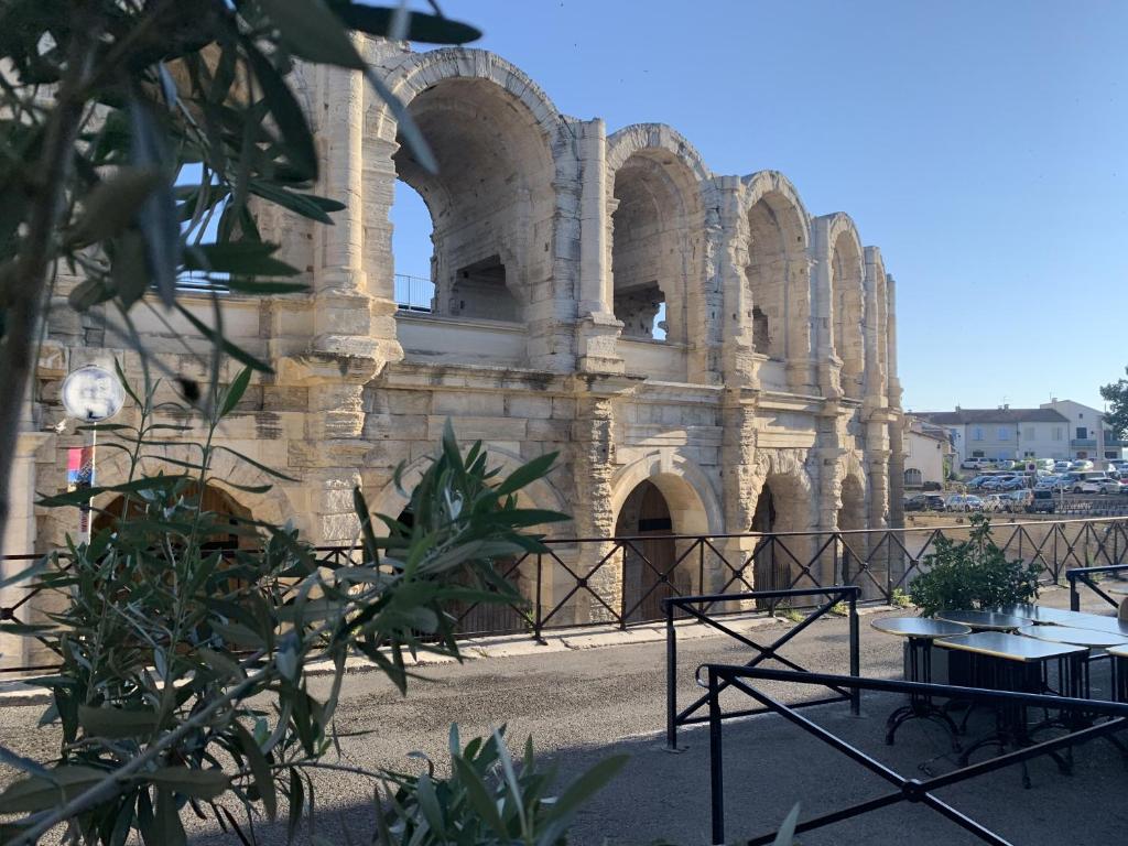 阿尔勒Holiday in Arles: Appartement de l'Amphithéâtre的前面有门和桌子的建筑