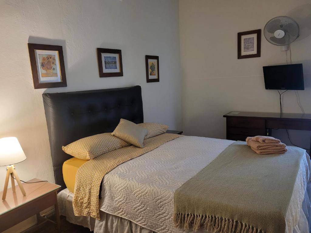 蒙得维的亚Hotel Ateneo的一间卧室配有一张床和一张带台灯的桌子