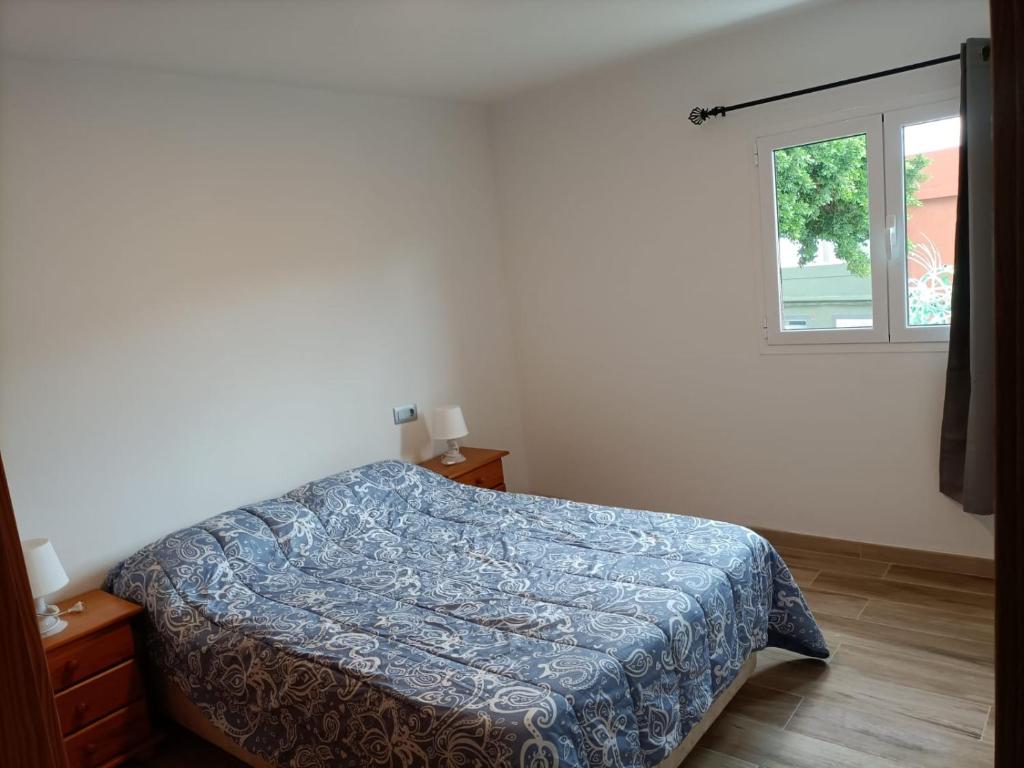 维辛达里奥Apartment Taliarte 36的一间卧室设有一张床和一个窗口