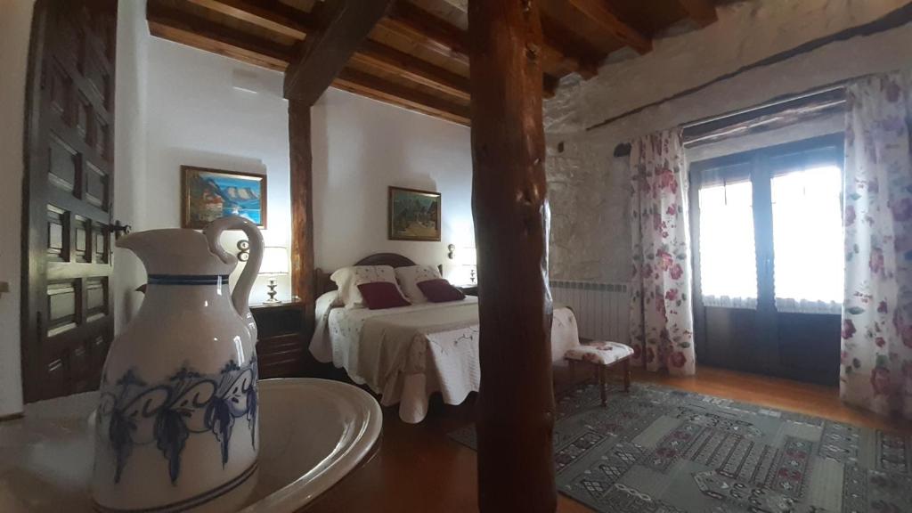 Castillejo de RobledoCasa rural Isabel y Fernando的卧室配有床和花瓶