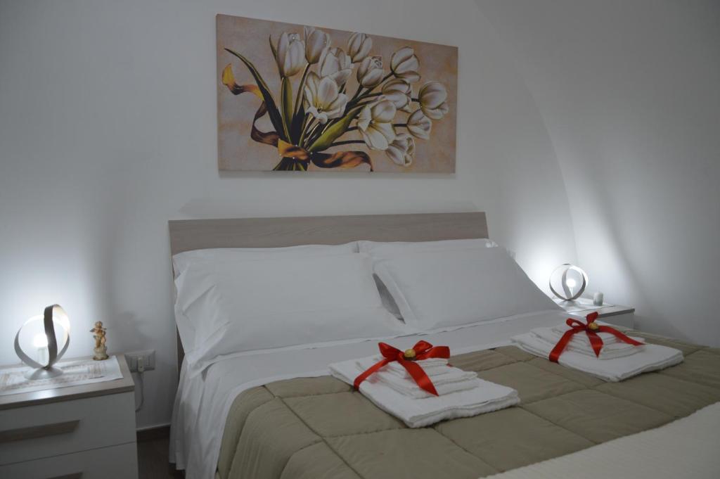 马泰拉Casa Nannina的一间卧室配有带2条毛巾和绘画的床