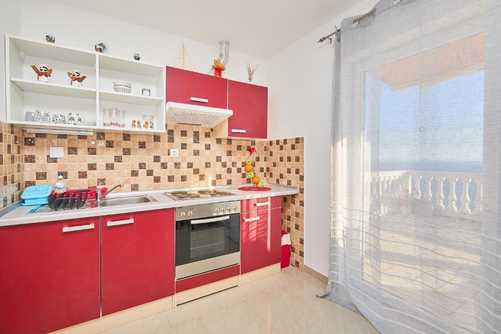 马拉诺维奇Apartments BARO的一间厨房,配有红色橱柜和大窗户