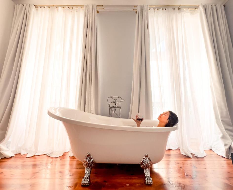 里斯本Palácio do Visconde - The Coffee Experience的坐在浴室浴缸里的女人