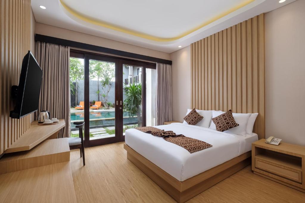 沙努尔ABISHA Hotel Sanur的一间卧室配有一张床、一台电视和一个游泳池