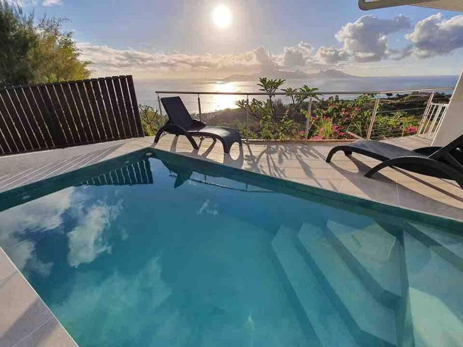 普纳奥亚Tahiti Moetama Cosy Lodge - VILLA ITI的一个带椅子的游泳池,享有海景