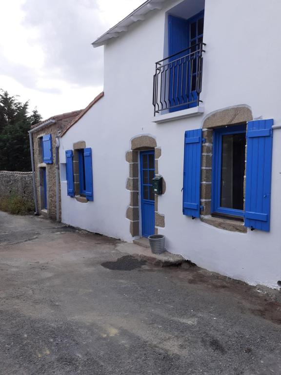 蒂福日GÎTE BARBE BLEUE的白色的房子,设有蓝色的窗户和蓝色的百叶窗