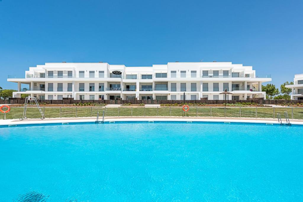 科斯塔巴伦娜Costa Ballena - Playa Azul Beach House的一座大型建筑,前面设有一个大型游泳池