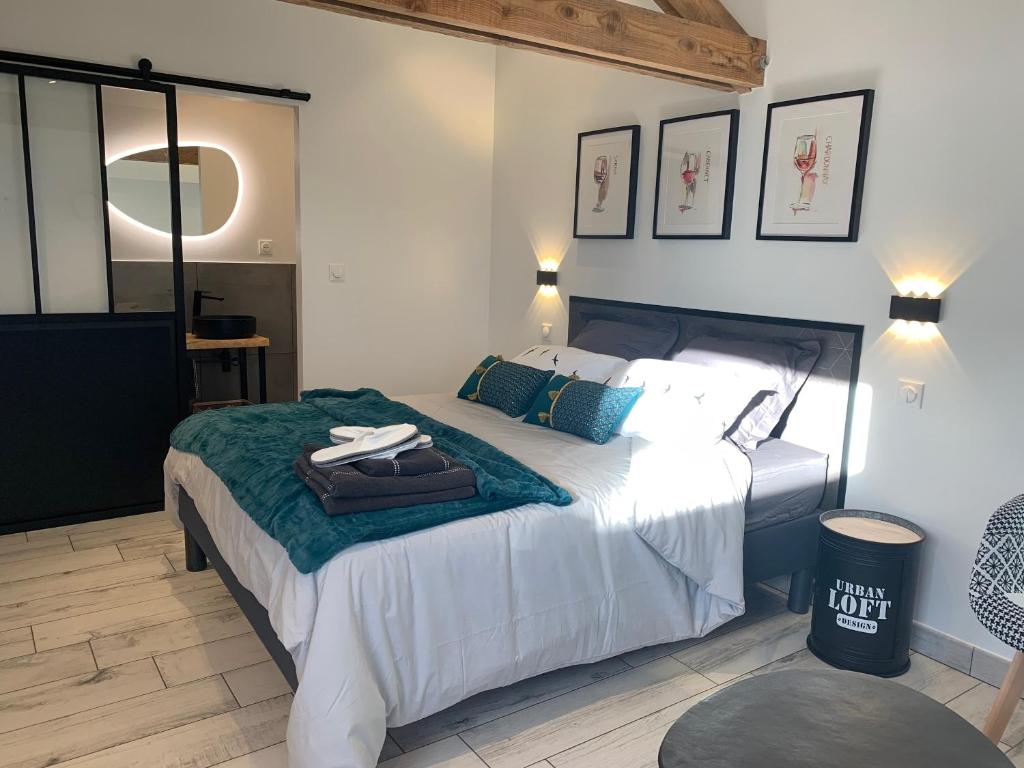 Sainte-ColombeLa Glycine B&B的一间卧室配有带白色床单和蓝色枕头的床。