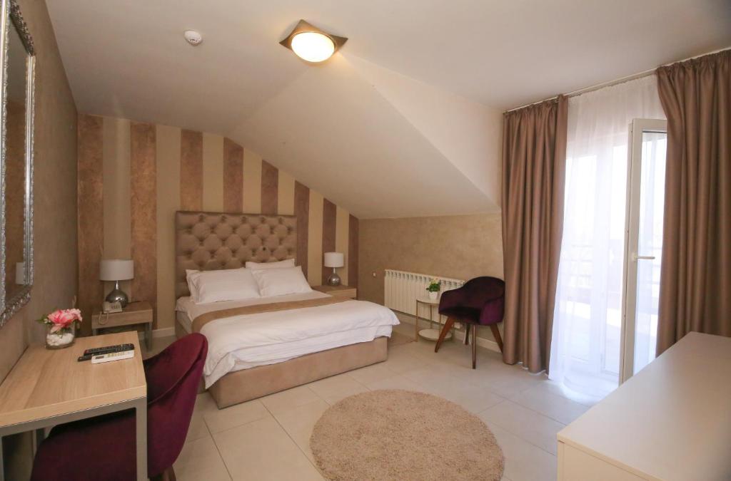 贝尔格莱德Bajadera Lux的一间卧室配有一张床、一张书桌和一个窗户。