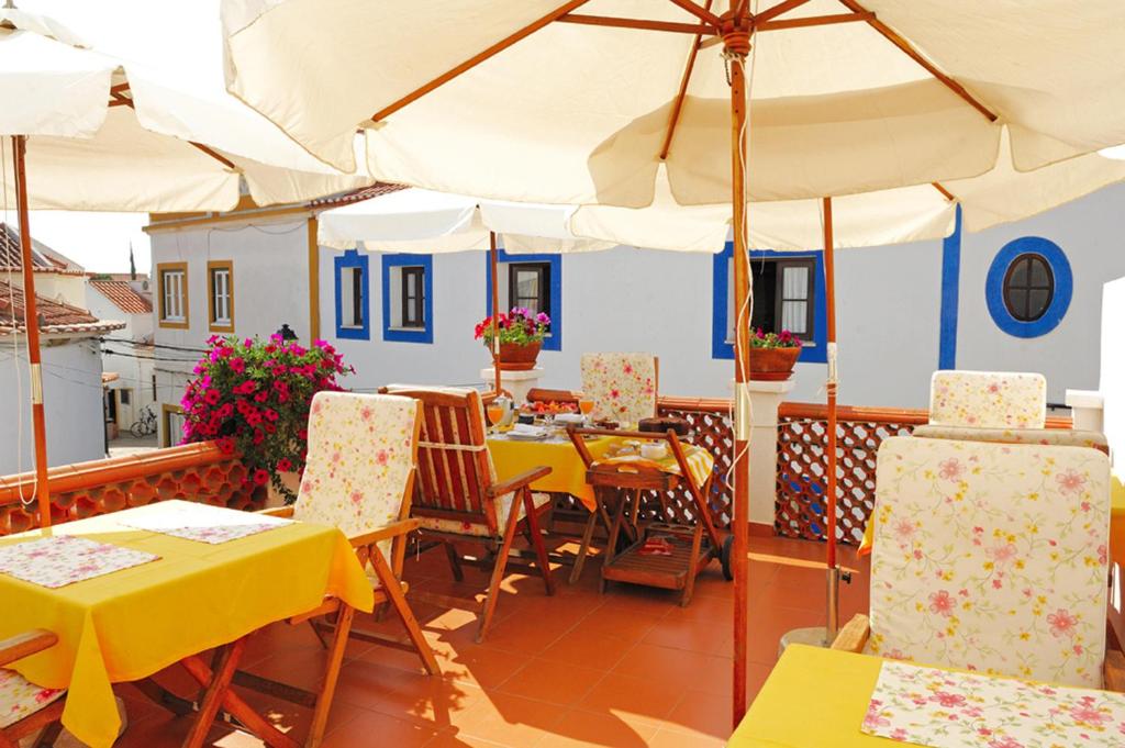 米尔芳提斯城阿德鲁之家旅馆的一间带桌椅和遮阳伞的餐厅