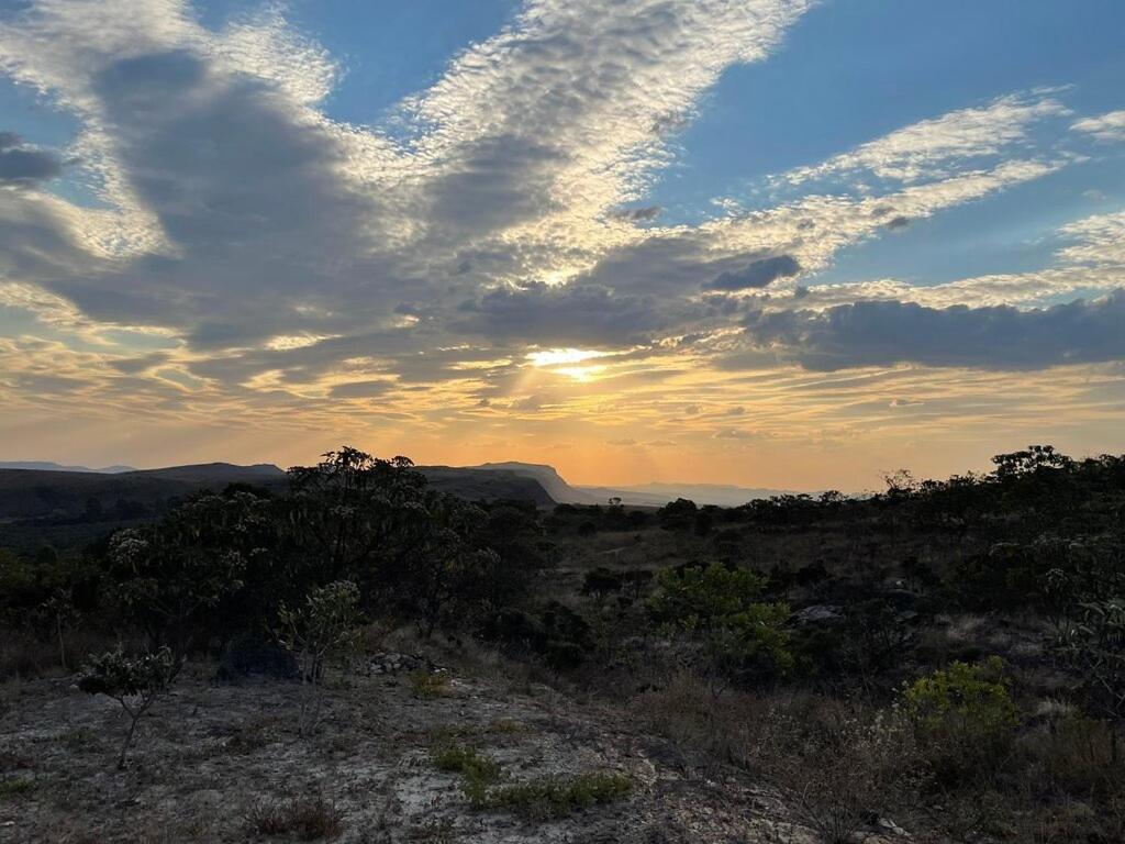 卡兰卡斯Pousada Serra da Paz的一片云天的田野上的日落
