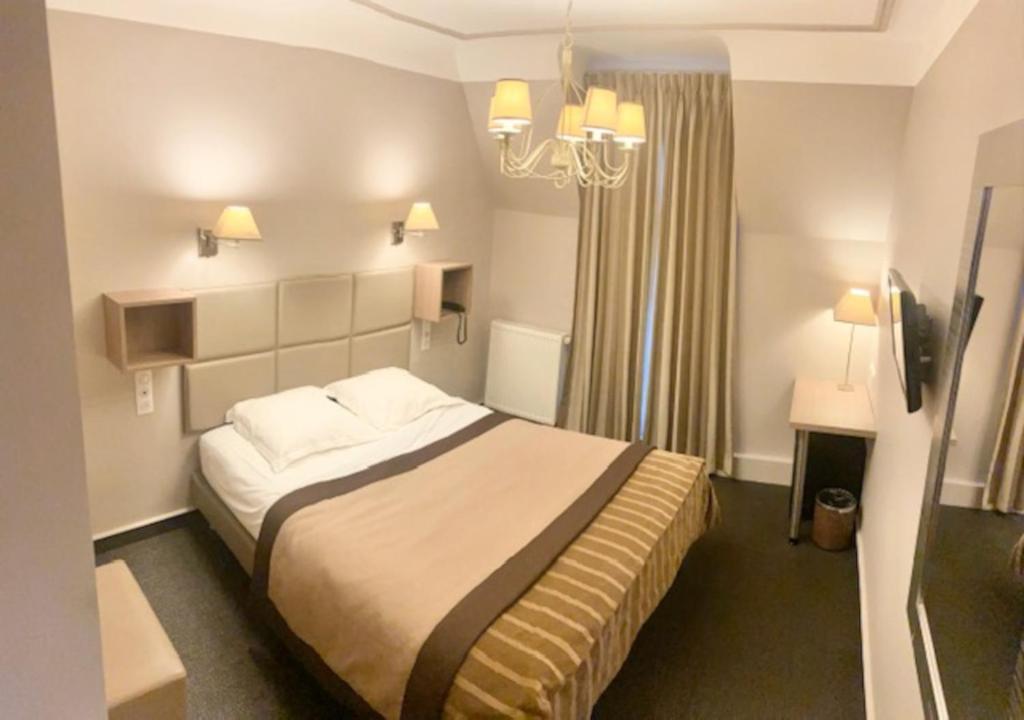 巴黎圣皮埃尔酒店的酒店客房,配有一张床和吊灯