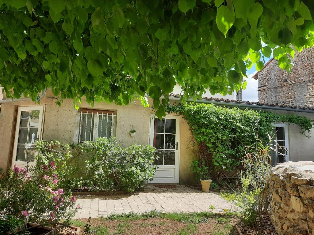 Vendeuvre-du-PoitouLe clos du coteau的一座有白色门和一些植物的房子