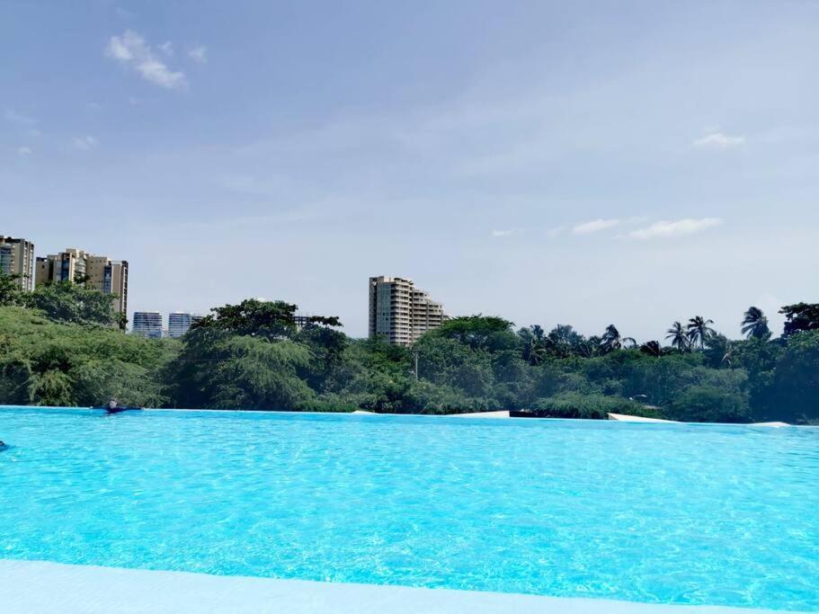圣玛尔塔Pozos colorado Bello horizonte - Apartamento 70 mt2的一大片蓝色的水,有建筑背景