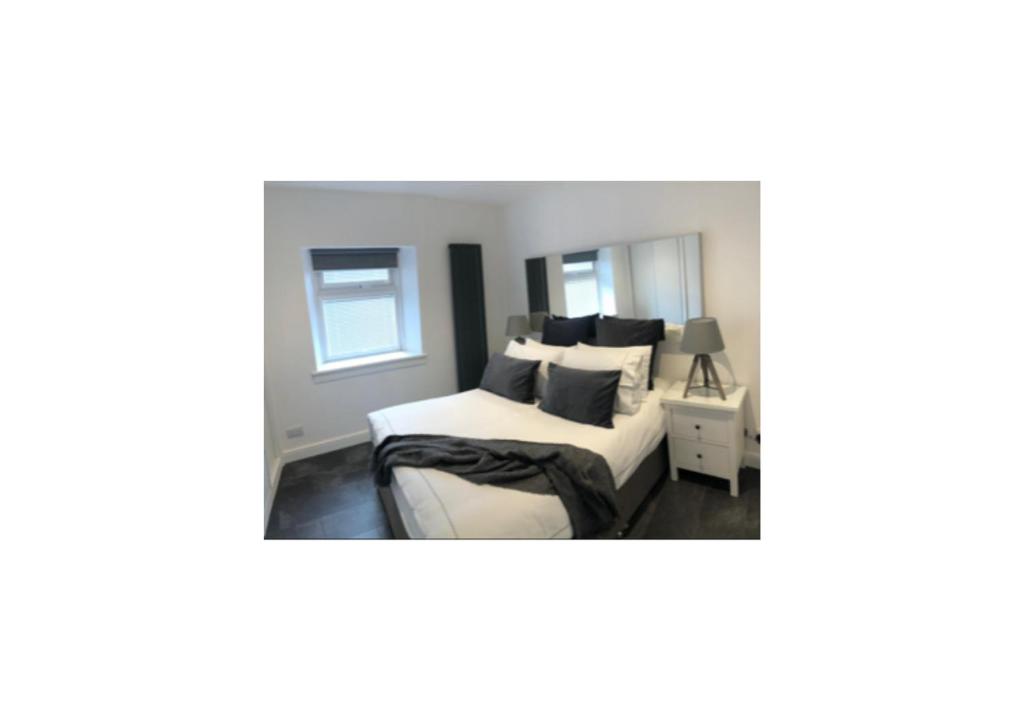 因弗内斯Grey Apartment的一间卧室配有一张带黑白枕头的床
