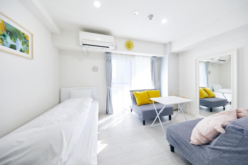 大阪Montana Flat Yebisu的一间卧室配有一张床、一张沙发和一张桌子
