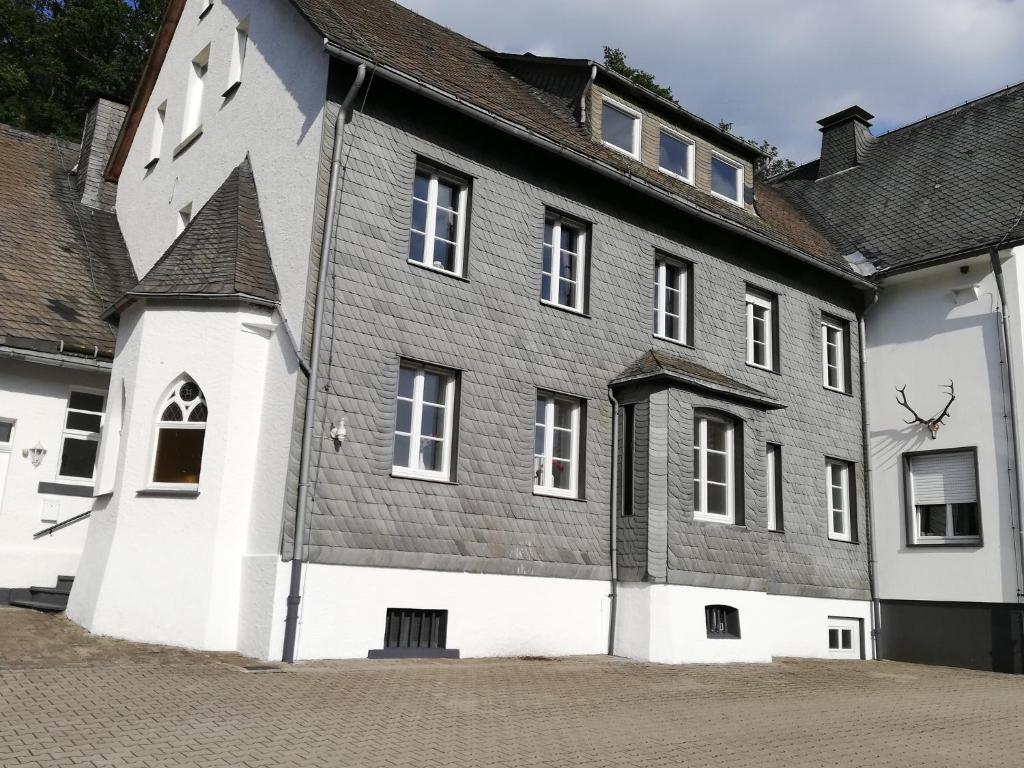 温特贝格Jagdschloss Siedlinghausen的一座白色的大建筑,有灰色的屋顶