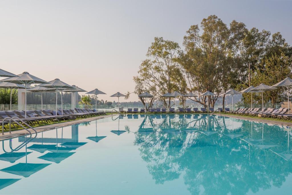 科梅诺Rodostamo Hotel & Spa- Adults Friendly的一个带椅子的游泳池,海水蓝色
