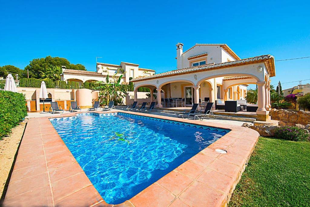 卡尔佩Villa Almendros - PlusHolidays的房屋前有游泳池的房子